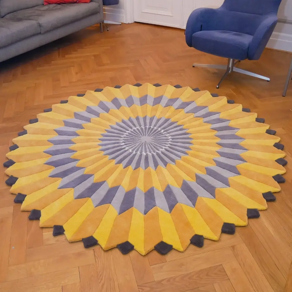 La peinture artistique « Rosette NY » d'Annika Johansson sous forme de tapis fait main jaune et gris. Tapis rond de forme unique.