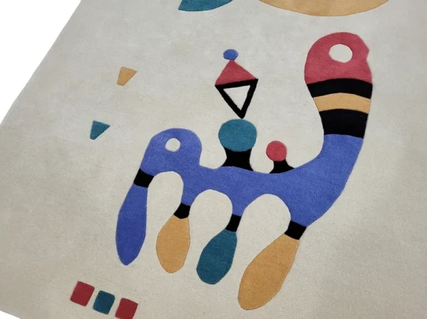 Gros plan sur tapis fait main par Rug Your Life, inspiré du tableau « Composition » (1944) de Wassily Kandinsky. Les couleurs du tapis sont le blanc crème, le bleu, le rouge et le vert.