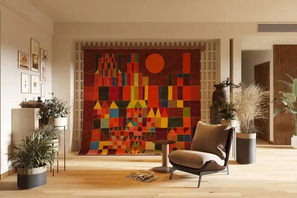 Il dipinto di Paul Klee “Castello e sole” trasformato in un tappeto fatto a mano da Rug Your Life. I colori del tappeto sono rosso bruciato, arancione e giallo. Appeso alla parete del soggiorno.
