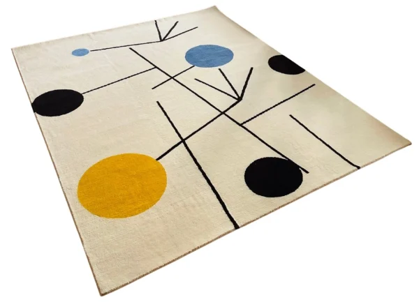 Tapis artisanal sur mesure inspiré du tableau « Équilibre » de Sophie Taeuber-Arp. Les couleurs principales du tapis sont le blanc, le jaune, le bleu et le noir. Tapis en édition limitée numérotée, par Rug Your Life.