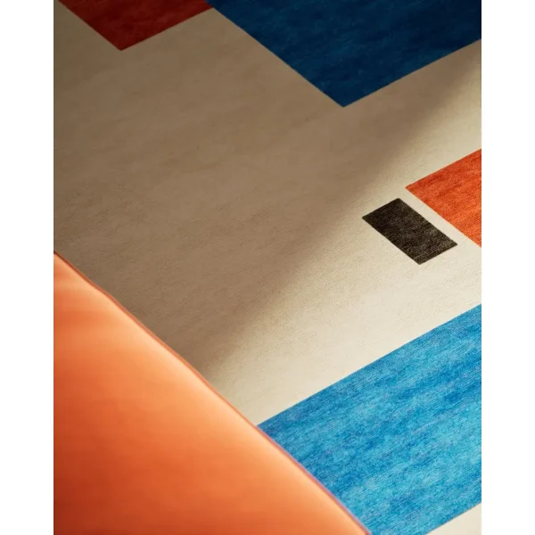 Handgeknüpfter Sonderteppich nach Piet Mondrian "Komposition in Farbe A". Die Basis des Teppichs ist cremefarben und die abstrakten geometrischen Elemente sind in blau, orange, rosa und schwarz gehalten