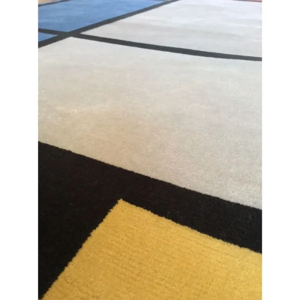 Primer plano de alfombra inspirada en Piet Mondrian «Composición con rojo, azul, negro, amarillo y gris», hecha a mano por encargo.