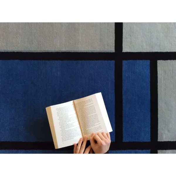 Primer plano de alfombra inspirada en Piet Mondrian «Composición con rojo, azul, negro, amarillo y gris», hecha a mano por encargo.