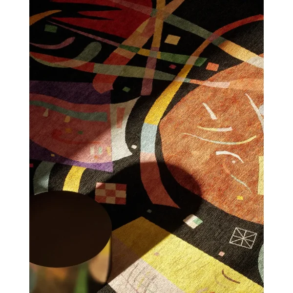 Nahaufnahme des Meisterwerks, das auf dem Kunstwerk Komposition X von Kandinsky basiert. Mit seinem schwarzen Grundton und den farbenfrohen Elementen ist der Teppich ein tolles Statement in dieser Lobby