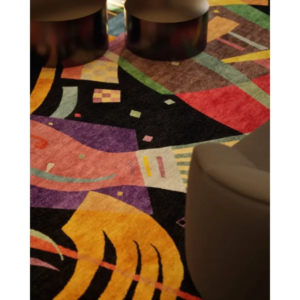 Nahaufnahme des Meisterwerks, das auf dem Kunstwerk Komposition X von Kandinsky basiert. Mit seinem schwarzen Grundton und den farbenfrohen Elementen ist der Teppich ein tolles Statement in dieser Lobby