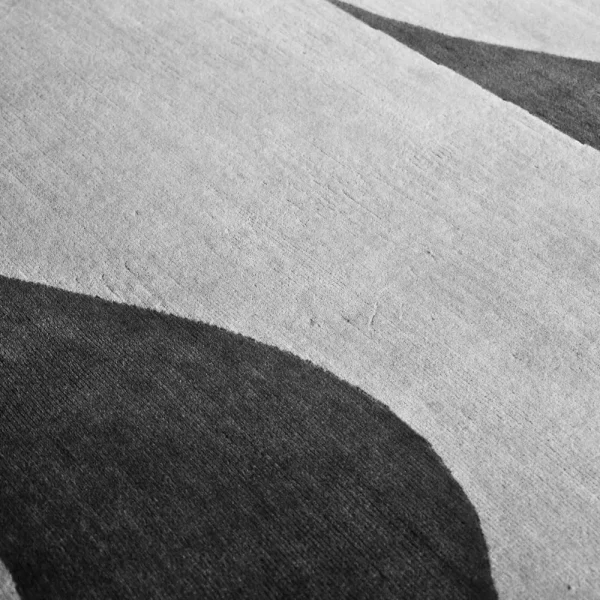Nahaufnahme geometrischer elfenbeinweißer und anthrazitgrauer Felder.