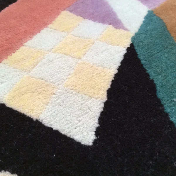 Nahaufnahme des Gemäldes „Komposition X“ von Wassily Kandinsky als handgefertigter Teppich von Rug Your Life. Die Hauptfarbe des Teppichs ist Schwarz, mit vielen leuchtenden Farben.
