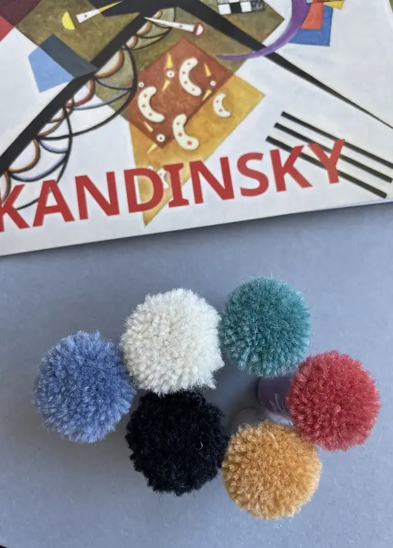 Des pompons choisis pour un tapis fait main sur mesure d'après le tableau « Composition » (1944) de Wassily Kandinsky.