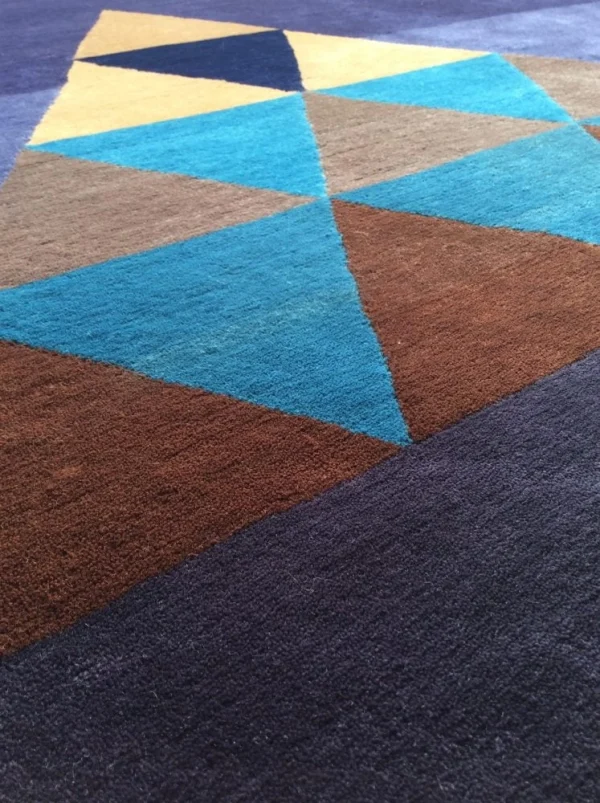 Nahaufnahme des handgefertigten Kandinsky-Teppichs “Conclusion” mit Wolltextur und geometrischem Dreiecksmuster
