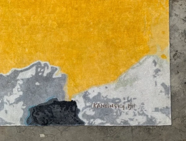 Närbild av Kandinskys signatur på den handgjorda mattan som specialtillverkats av Rug Your, inspirerad av Wassily Kandinskys målning ”Intryck III (Konsert)”.